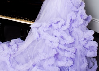 woman in purple off-shoulder dress holding bouquet of flowers