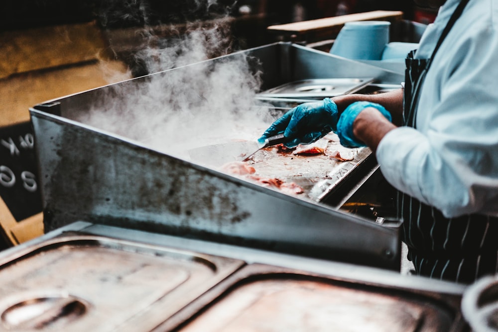 man grilling meat at kitchen