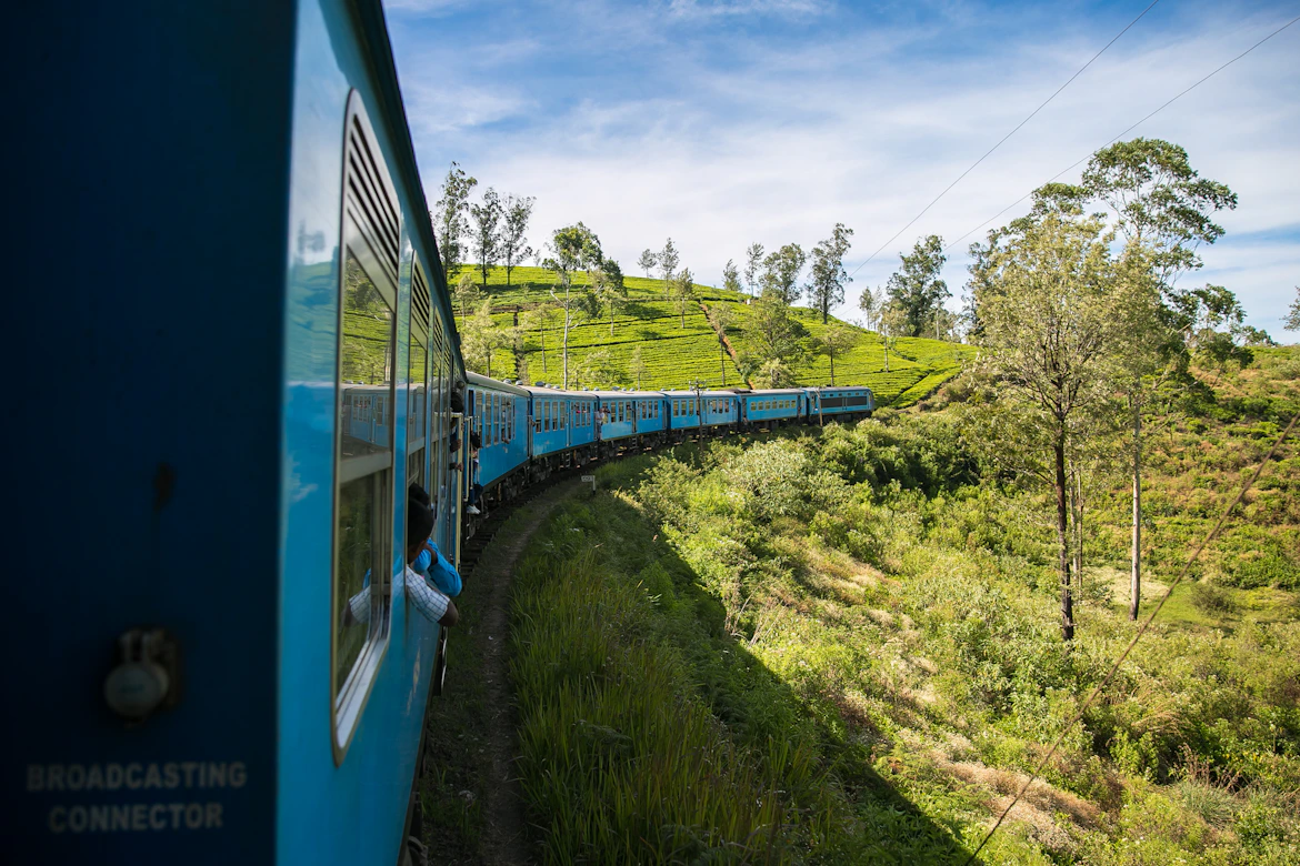 A classic blue train moving through Sri Lanka's tea hills