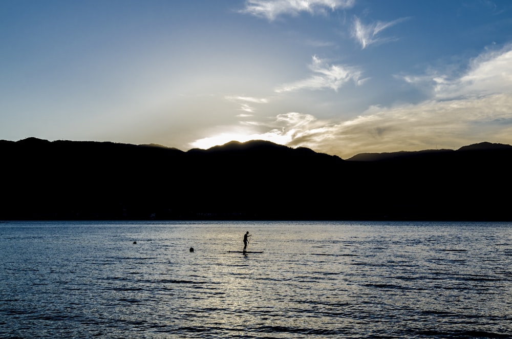 sunrise on mountains near body of water