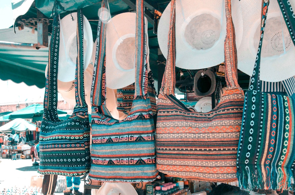 four assorted-color-and-design shoulder bags on display