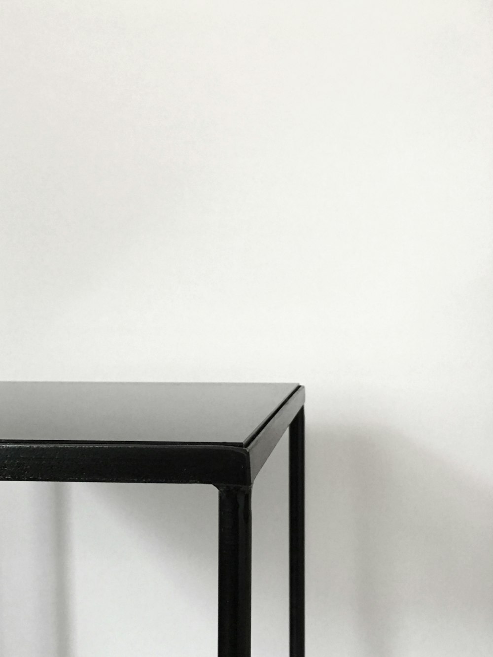 tavolo in metallo nero vicino a parete bianca appannata