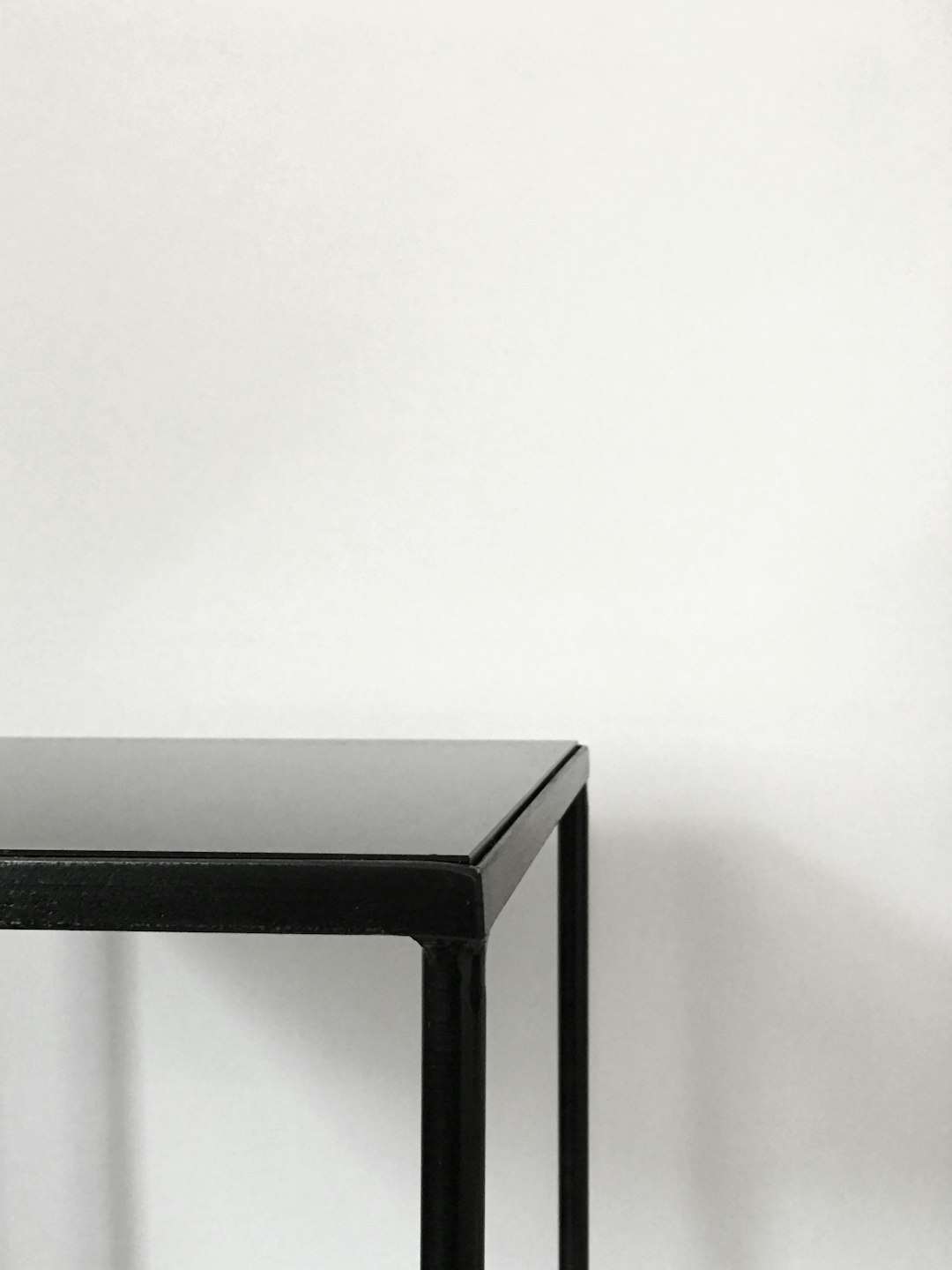  black metal table near white panted wall table