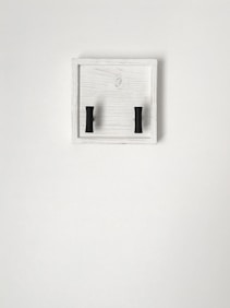 a pair of black handles on a white wall