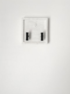 a pair of black handles on a white wall