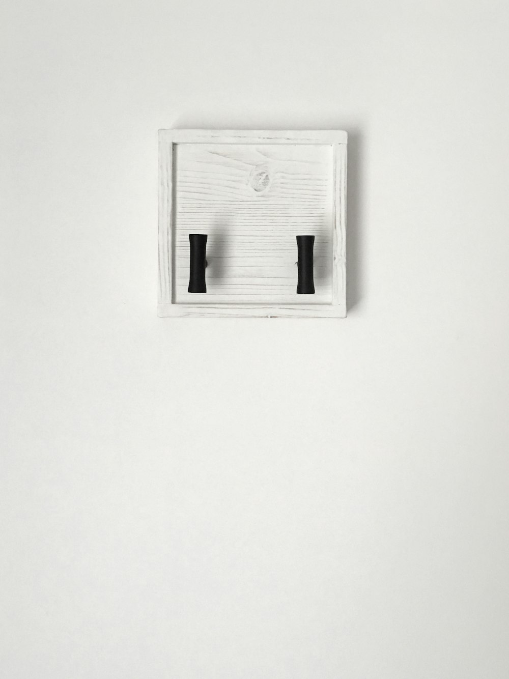 a pair of black handles on a white wall