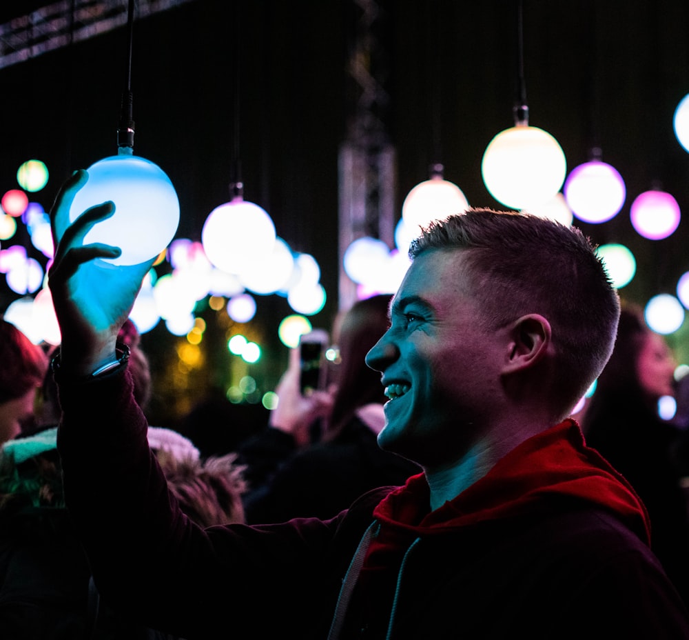 man holding ball lamp while smiling