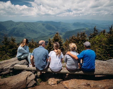 group of people sitting on rocks overlooking mountain