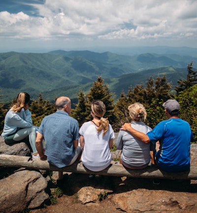 group of people sitting on rocks overlooking mountain