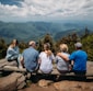 group of people sitting on rocks overlooking mountain