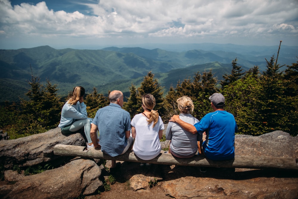 Gruppe von Menschen, die auf Felsen mit Blick auf den Berg sitzen