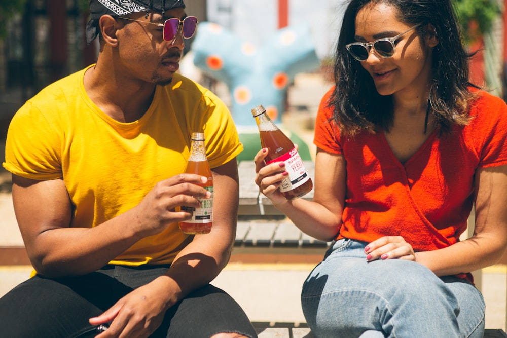 man and woman holding bottles of drinks