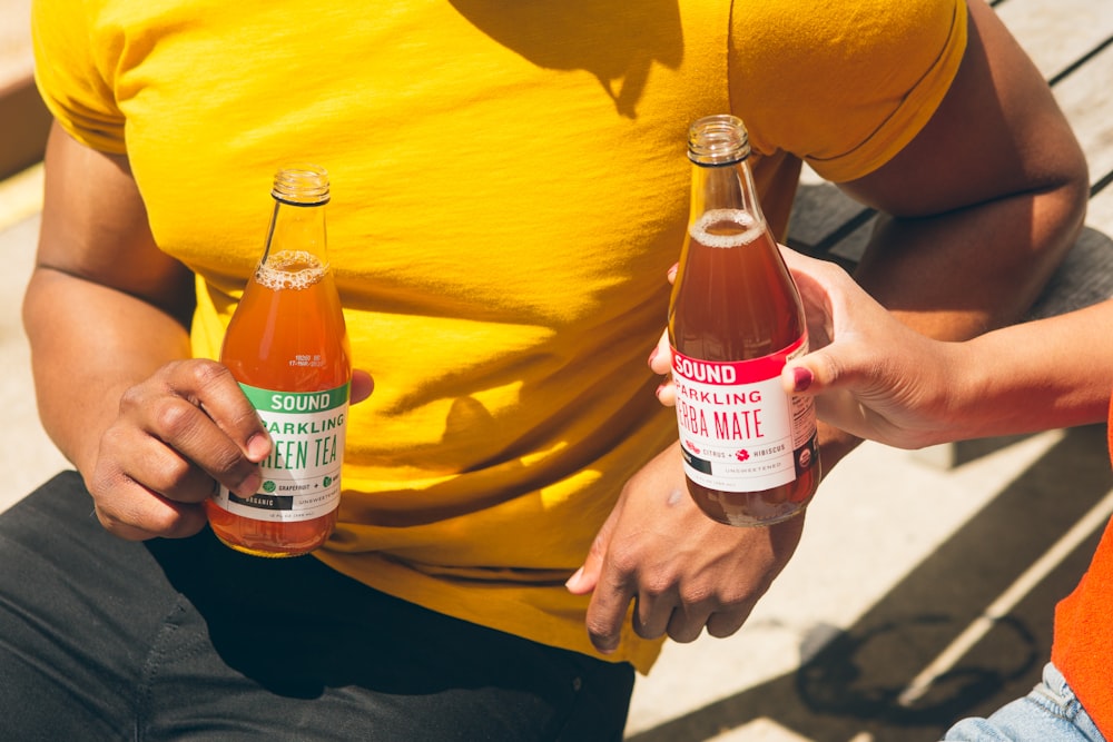 men holding two tea bottles