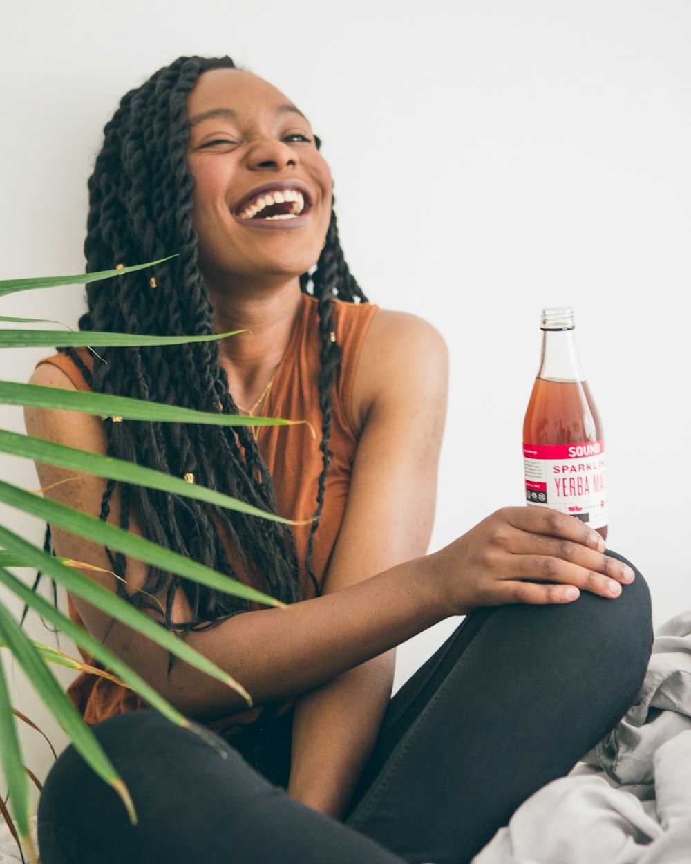 woman sitting while holding liquid bottle