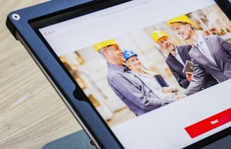 iPad with four business persons shaking hands display