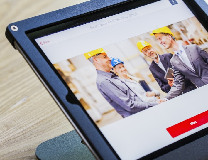 iPad with four business persons shaking hands display