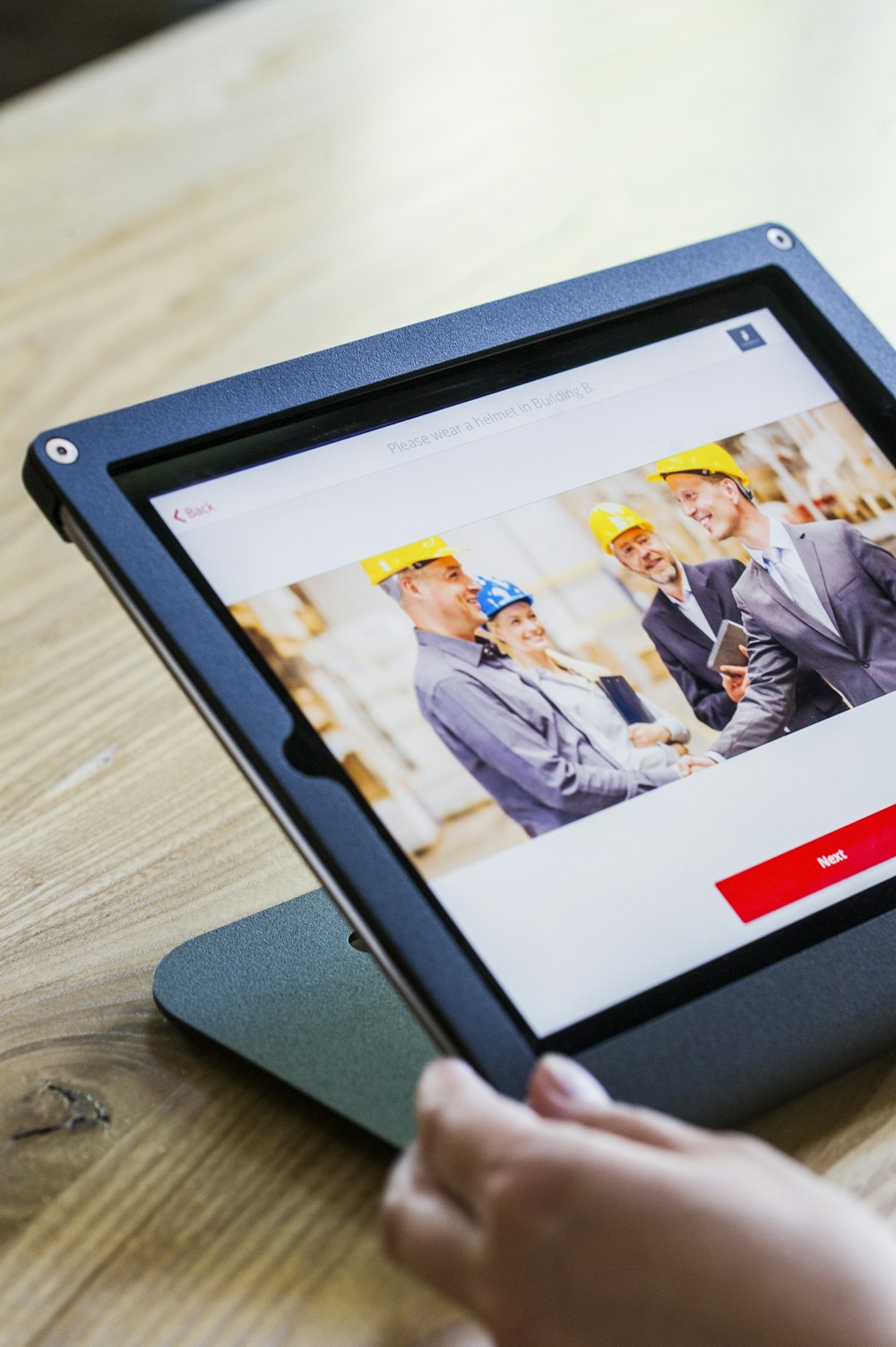 iPad with four business persons shaking hands display