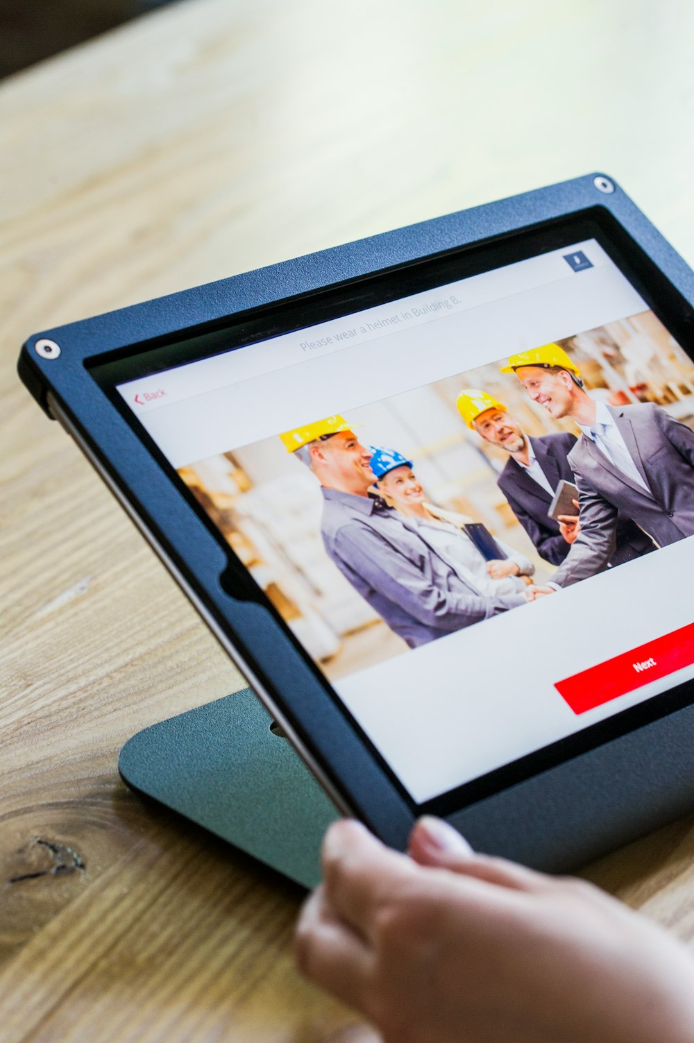 iPad with four business persons shaking hands display