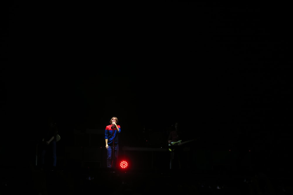 a man standing in the dark with a red light