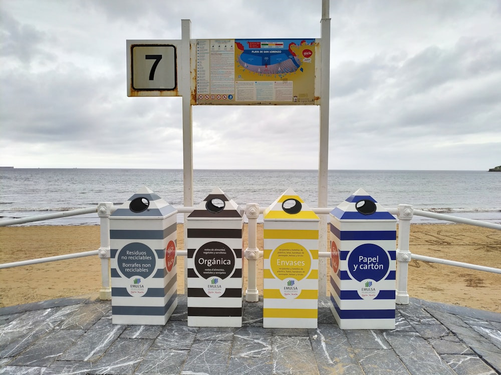 gray, black, yellow, and blue trash bins