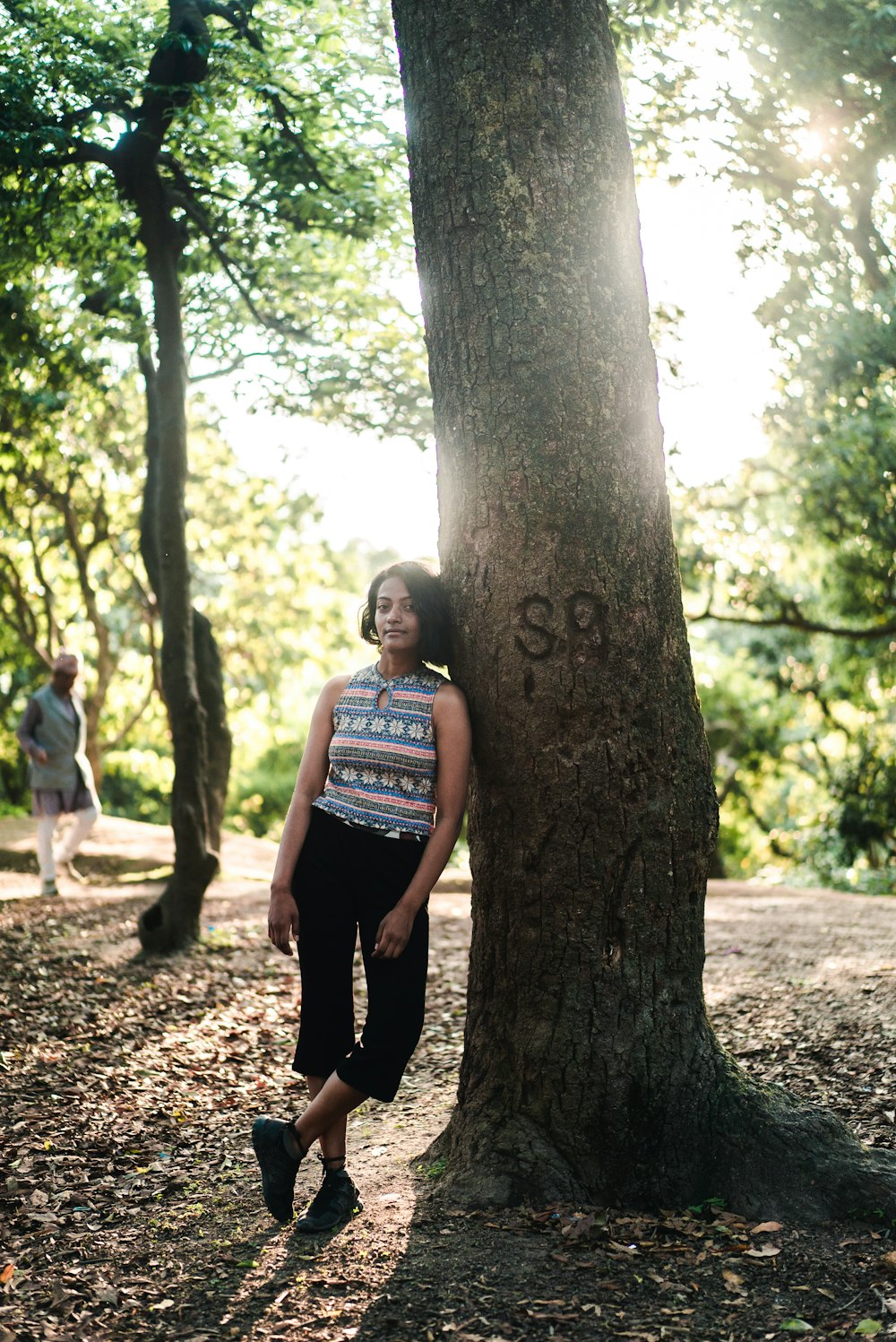 man leaning beside tree