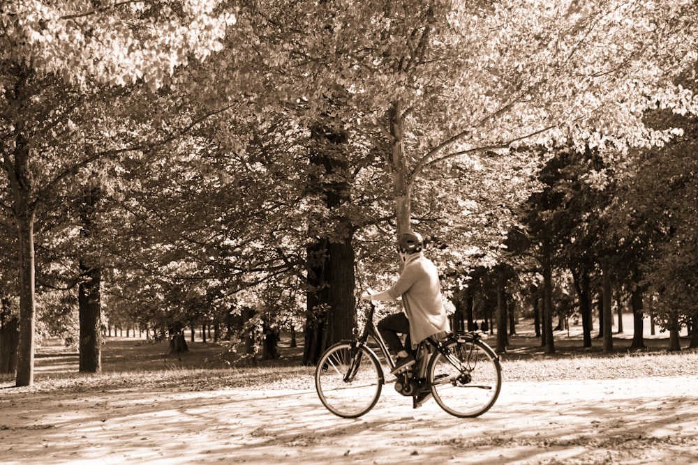 sepia photography of man riding bicycle