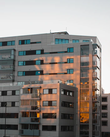 A sleek, modern office building in Noida bathed in warm evening light.