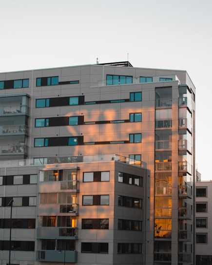 Modern residential building with clean lines and large windows at sunset.