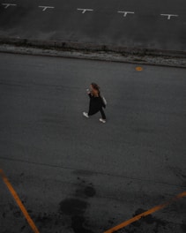 A friendly student using a smartphone app to find an empty parking spot on a vibrant university campus.