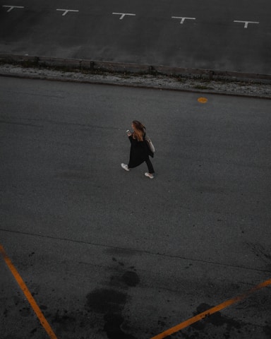 A friendly student using a smartphone app to find an empty parking spot on a vibrant university campus.