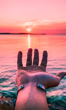 Stylish bracelets displayed on a sandy beach background with sunset hues.
