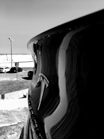 A polished Tesla Model S gleaming under the warm Arizona sun with the Phoenix skyline faintly visible.