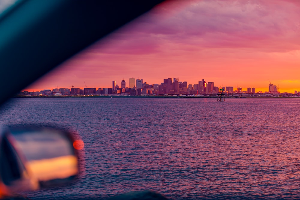 city skyline near body of water during dusk