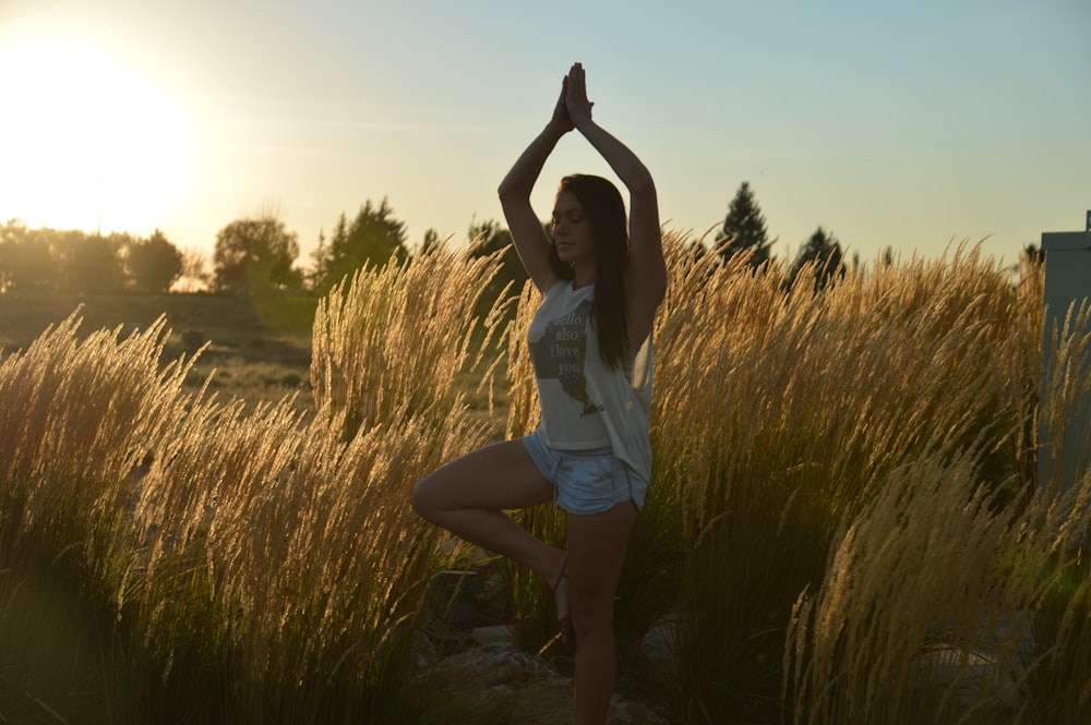 woman doing yoga pose outside near grass