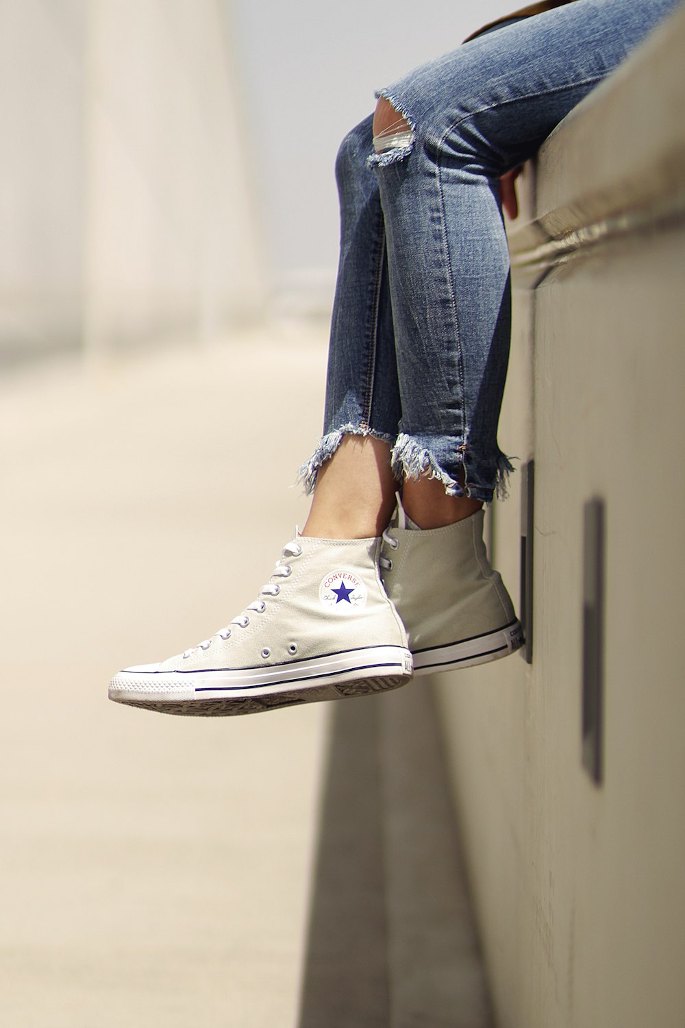 woman wearing white Converse low-top sneakers