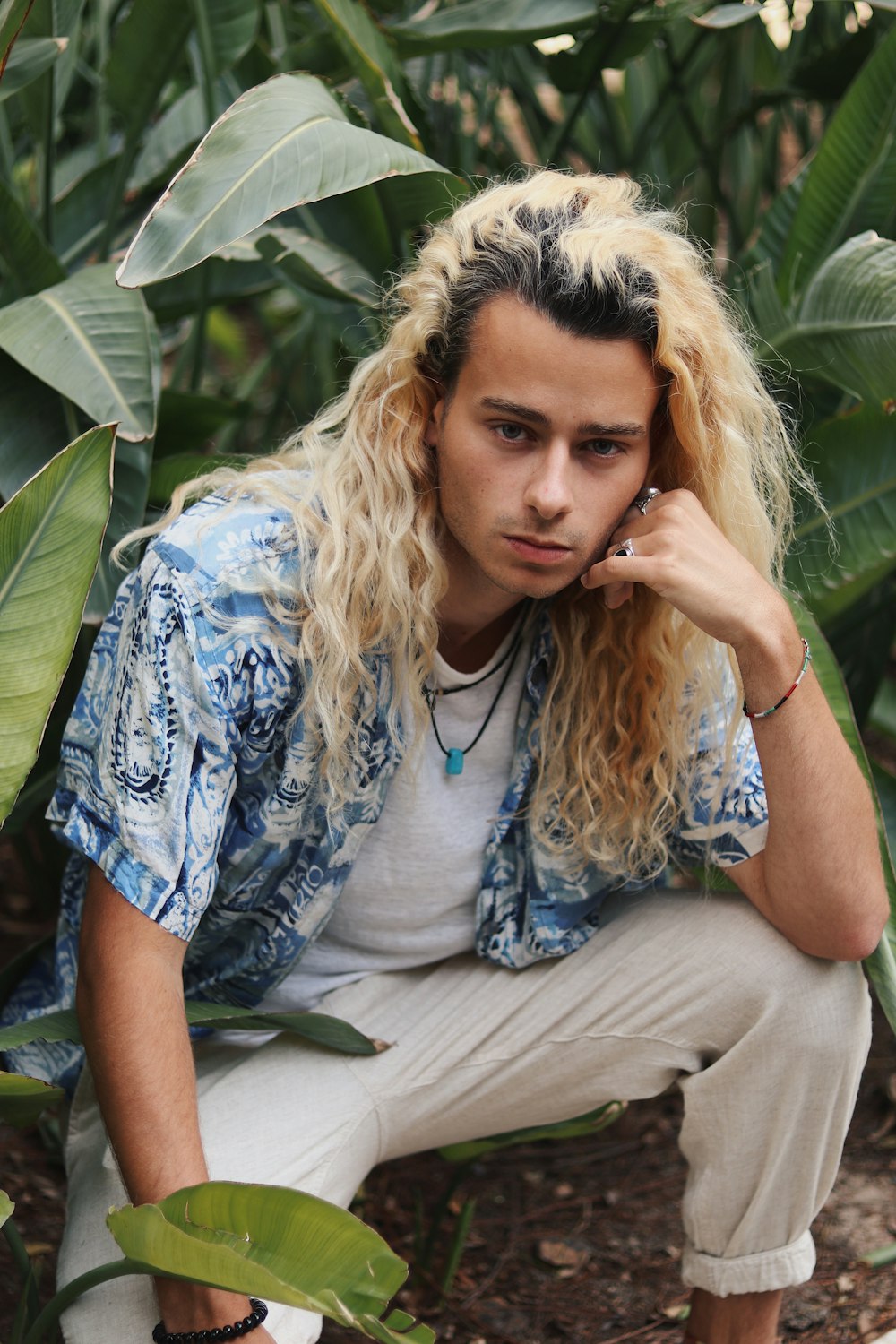 man sitting beside plant