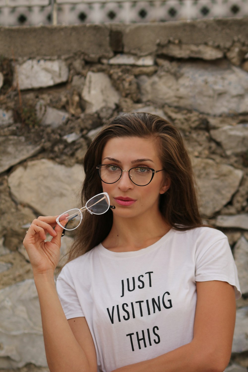 woman holding eyeglasses outside