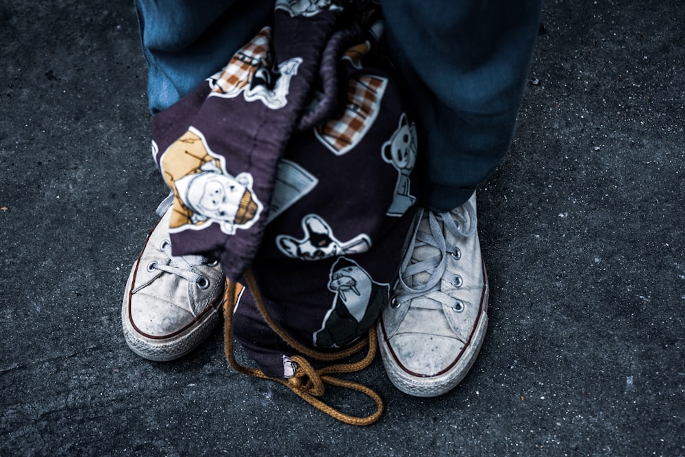 fabric drawstring backpack between man's feet