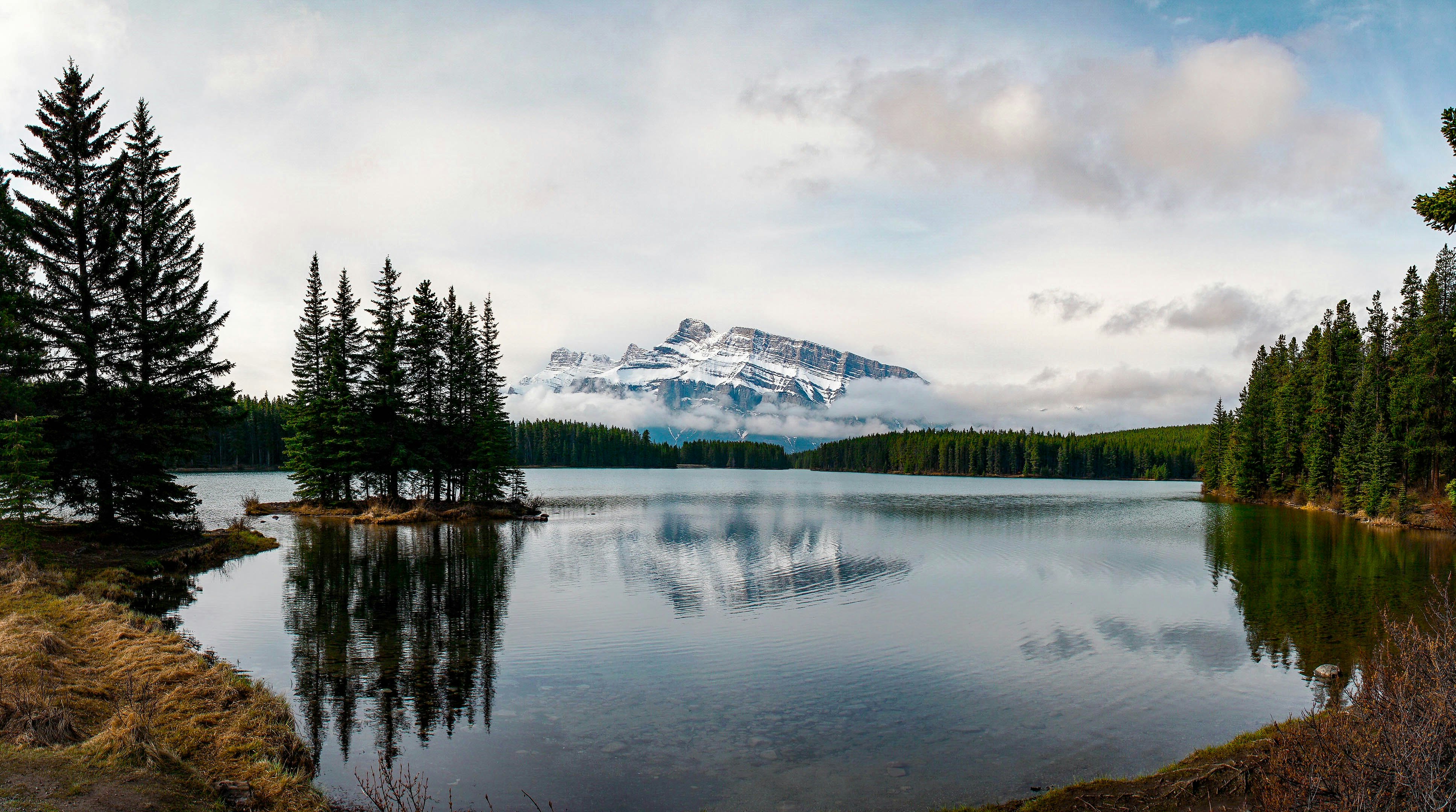 landscape photo of snow covered mountain near body of water during daytime