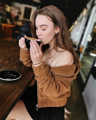 A serene scene of a woman enjoying coffee in a cozy cafe.