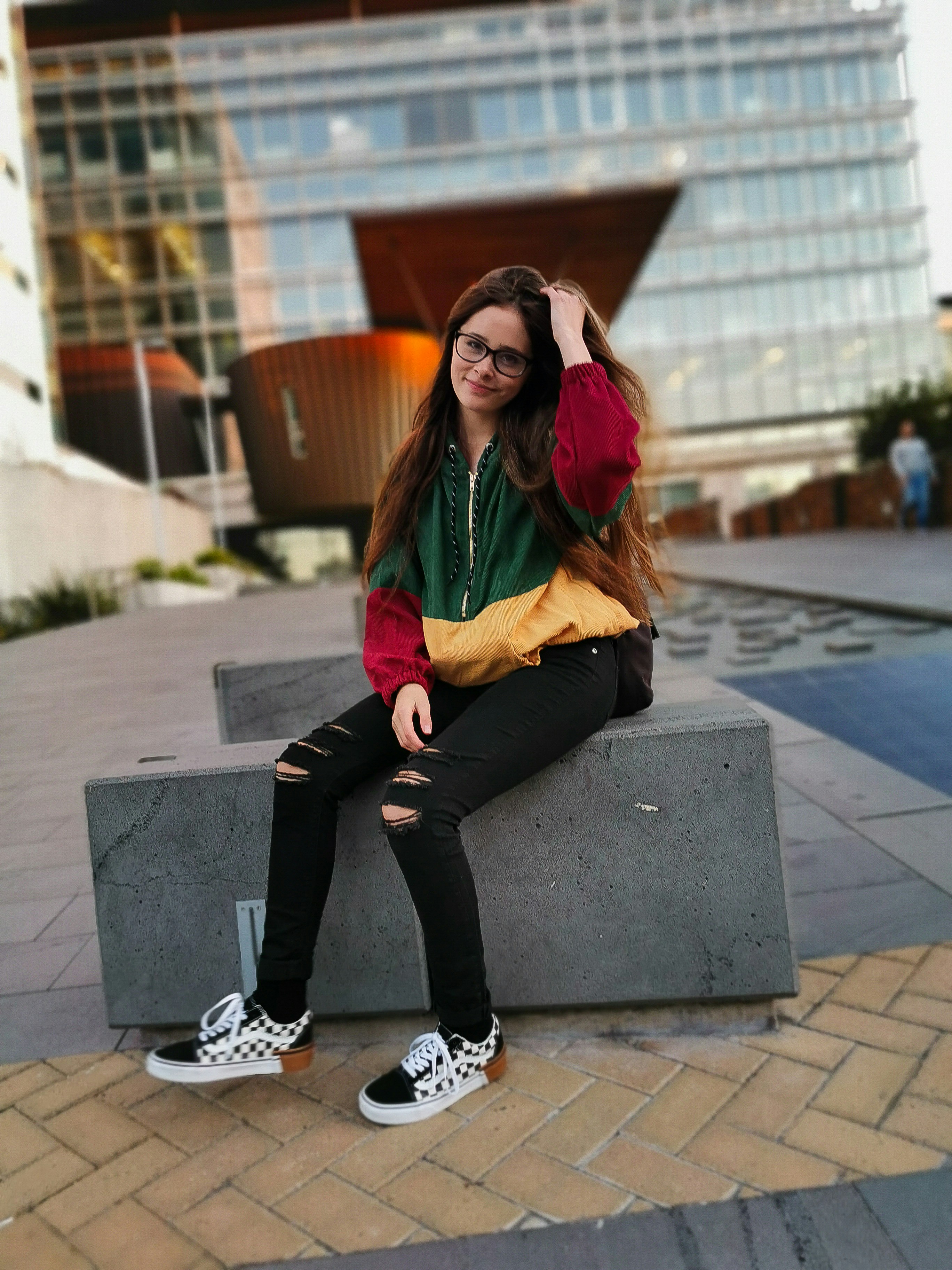 women's green jacket sitting on concrete