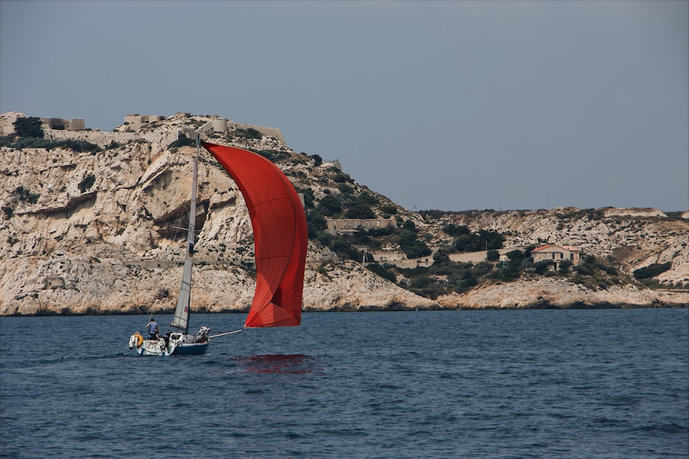 red and gray sailboat on seat during daytime