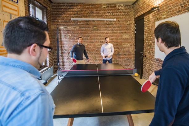 A lively group of table tennis players sharing a joyful moment after a match.