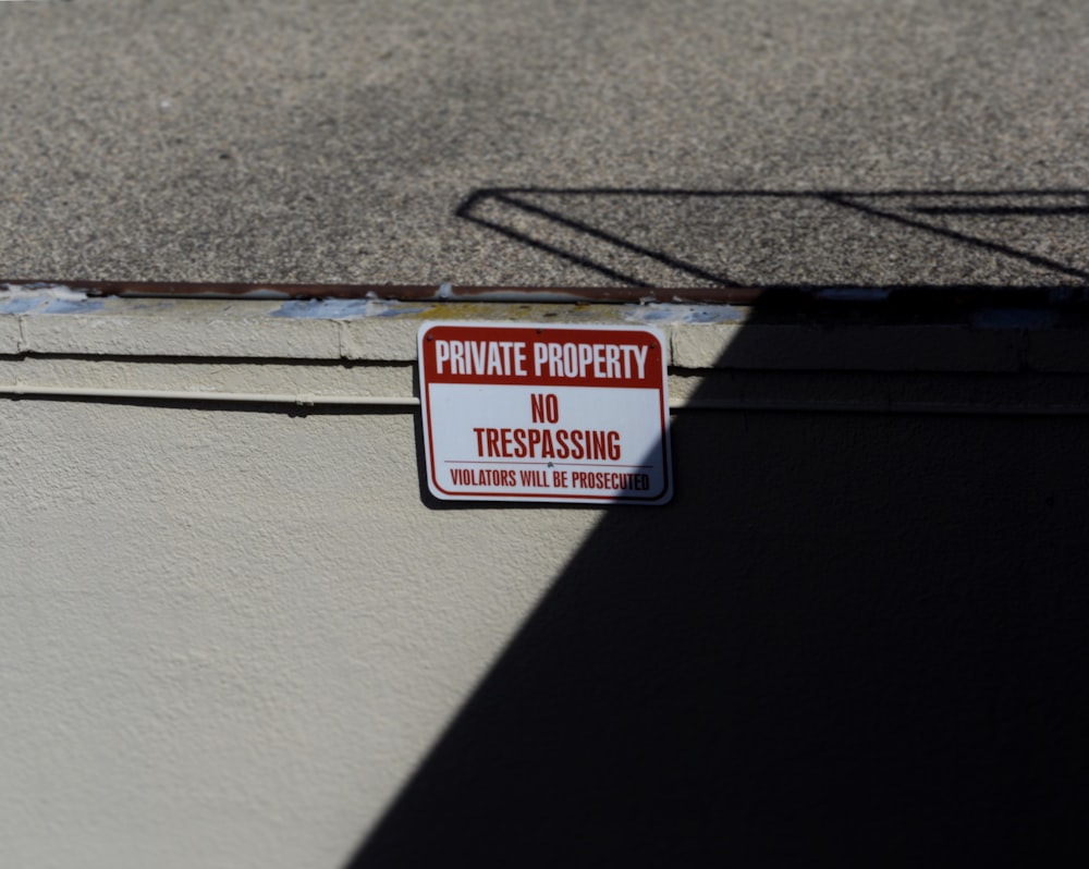 white and red Private Property No trespassing signboard