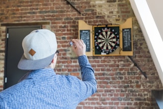 man in blue dress playing dart