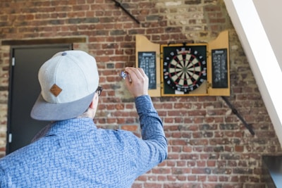 man in blue dress playing dart