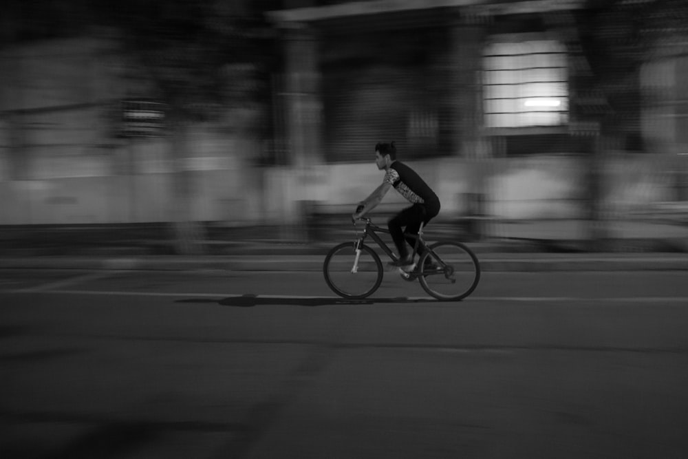 hombre montando en bicicleta en carretera asfaltada