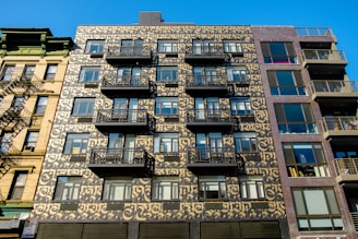 The exterior facade of a luxury apartment building with gold-accented design elements.
