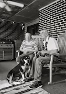 grayscale of man and woman sitting on wooden rocking chairs