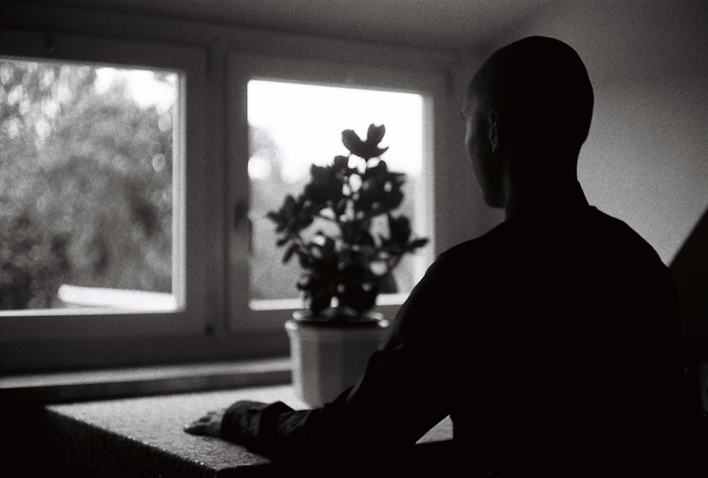 person sitting in front of table with plant